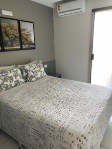 a bedroom with a bed with a white comforter at flat 013 - Serra Negra - Bezerros - PE in Bezerros
