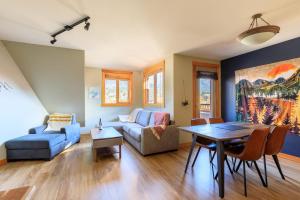 a living room with a couch and a table at Boardwalk Bliss - Top Floor Downtown Condo in Canmore