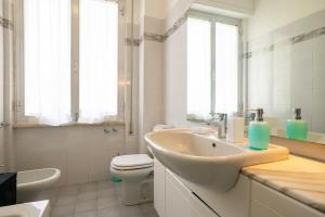 a white bathroom with a sink and a toilet at La Casa del Sole-Viareggio in Viareggio +31 photos