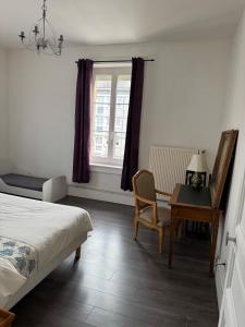 a bedroom with a bed and a desk and a window at Appartement 3 chambres 6 personnes in Sedan