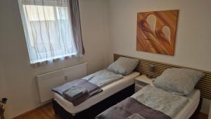 two twin beds in a room with a window at Weisenau-Schlafbereich - Einzel-oder Doppelbett in Mainz