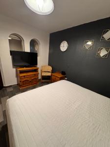 una camera da letto con un letto e un orologio a parete di Casita EA in the heart of the Historic Center of Oaxaca a Città di Oaxaca Altre 27 foto