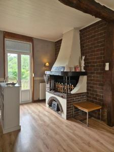 a living room with a brick fireplace in a room at Maison de Caractère 4-8 Pers in Lumbres