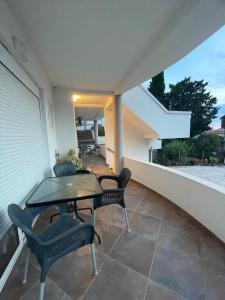 a patio with a table and chairs on a balcony at belaapartmani in Bar
