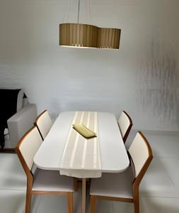 a white table with chairs and a book on it at T501 - Apto Novo Ar cond Cama Queen Vaga in Vitória