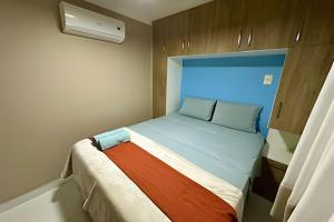 a small bed in a small room with a window at T501 - Apto Novo Ar cond Cama Queen Vaga in Vitória