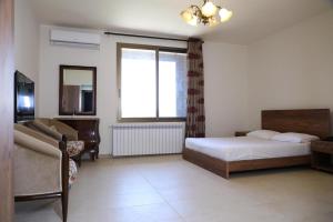 a bedroom with a bed and a couch and a window at LaForge Resort 