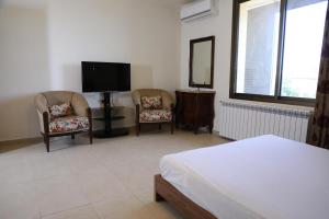 a bedroom with two chairs and a flat screen tv at LaForge Resort 