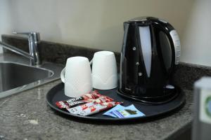 a coffee maker and two cups on a counter at LaForge Resort  +7 photos