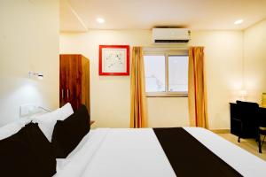 a bedroom with a white bed and a window at Super Townhouse De Alphabet Hotel - Gandimaissamma in Hyderabad