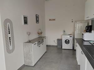 a kitchen with a refrigerator and a washing machine at studio près de cergy calme in Ableiges