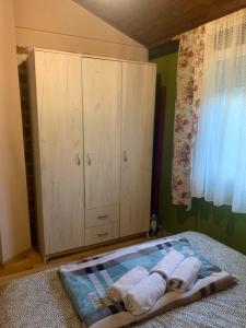 a bedroom with a cabinet and two towels on a bed at Drinski kucerak in Okletac