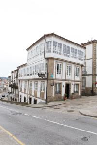 a large white building on the side of a street at Linares Rooms Santiago in Santiago de Compostela