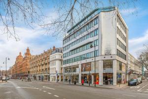a tall building on a city street with buildings at Harrods Platinum Pad in London