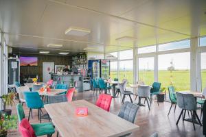 a dining room with tables and chairs and windows at Le Jardin Glamping in Oraviţa