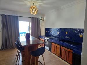 a kitchen with a counter and a table with chairs at Terrasse sur l'azur in Taghazout