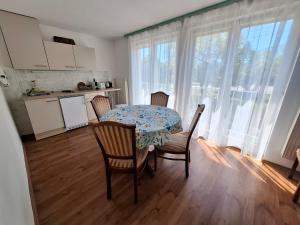 a kitchen with a table and chairs in a room at Napvirág - Közel mindenhez in Balatonakarattya