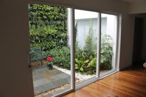 a sliding glass door with a garden outside at Casa Hotel Boyaca Real in Bogotá