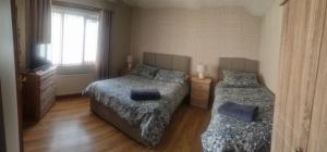 a bedroom with two beds and a television in it at Church View B&B in Ballycastle +19 photos