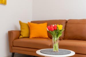 a vase of flowers on a table in front of a couch at Apartments Kvarner in Malinska +51 photos
