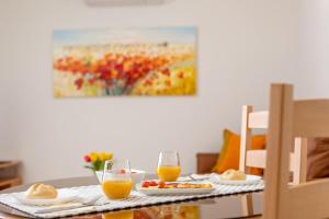 a table with food and two glasses of orange juice at Apartments Kvarner in Malinska