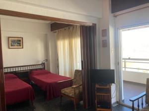 a hotel room with two beds and a television at Résidence El Prado in Cullera