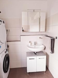 a white bathroom with a sink and a washing machine at Marlerei in Marl +5 photos