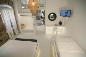 a room with two white beds and a tv at Axilleion Boutique Hotel in Ermoupoli