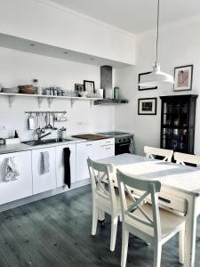una cucina bianca con un tavolo e delle sedie di Quinto between comfort and design a Genova