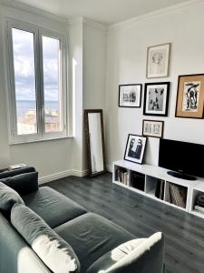 un soggiorno con un divano e una televisione di Quinto between comfort and design a Genova