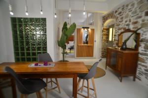 a dining room with a wooden table and chairs at Axilleion Boutique Hotel in Ermoupoli