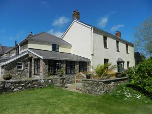 duży biały dom z kamienną ścianą w obiekcie Cilwen Country House Bed and Breakfast w mieście Abernant