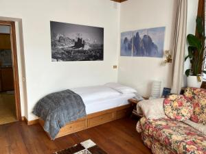a living room with a bed and a couch at Masito Apartments The Hub in Cortina dʼAmpezzo