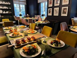 un lungo tavolo con piatti di cibo sopra di Boutique Hotel KRISTOFS a Riga