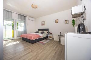 a bedroom with a bed in a white room at Dvokrevetna soba Lela in Crikvenica