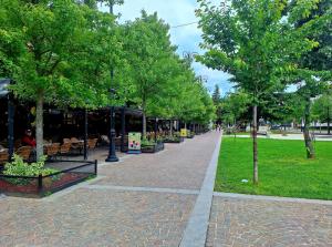 a sidewalk with trees in a park with a building at Apartment Kajon in Peje