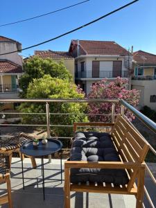 a balcony with a bench and a table and some buildings at Caruso Central Apartments in Lefkada