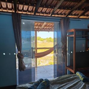 une chambre avec une porte vitrée donnant sur un patio dans l'établissement Hospedaria Coisa Linda Caraiva, à Porto Seguro