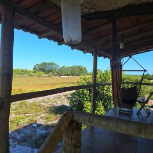 un porche avec un hamac et une vue sur un champ dans l'établissement Hospedaria Coisa Linda Caraiva, à Porto Seguro 13 autres photos