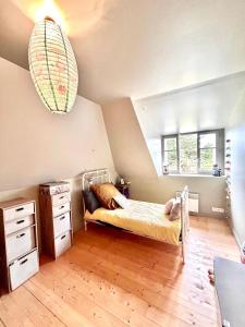 SantecにあるAgréable maison, au Dossen, à 2 pas de la plageのベッドとドレッサーと窓のある寝室