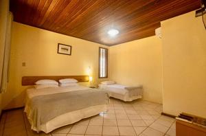 a bedroom with two beds and a wooden ceiling at Pousada dos Guarás in Salvaterra