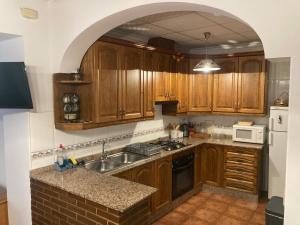 a kitchen with wooden cabinets and a sink at Casa Fuenteblanca in Liétor +10 photos