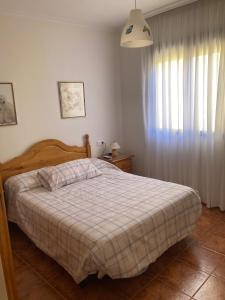 a bedroom with a bed with a blanket and a window at Casa Fuenteblanca in Liétor +5 photos