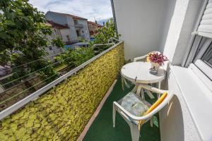 a small balcony with a table and chairs on a building at Dvokrevetna soba Lela in Crikvenica