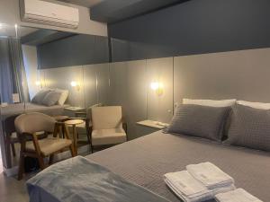 a bedroom with a bed and a table and chairs at Madrid Apartment in São Paulo