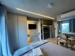 a hotel room with a bed and a television at Madrid Apartment in São Paulo