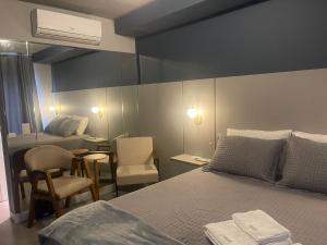 a bedroom with a bed and a table and chairs at Madrid Apartment in São Paulo +9 photos