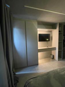 a bedroom with a sliding glass door with a tv at Madrid Apartment in São Paulo