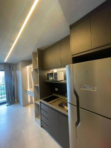 a kitchen with a stainless steel refrigerator and cabinets at Madrid Apartment in São Paulo