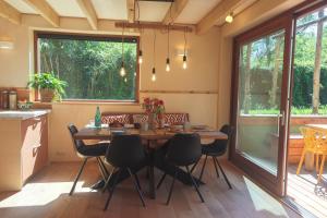a kitchen and dining room with a wooden table and chairs at Juneberry Ecolodge Bergen in Bergen